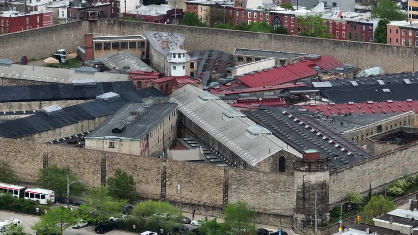 Aerial rotational shot of Eastern State Penitentiary. Historial prison in city center of Philadelphia, Pennsylvania. Famous correctional facility formerly holding hundreds of convicts frozen in time.
