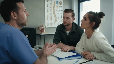 Caucasian doctor and heterosexual couple discussing medical exam results. Shot with RED helium camera in 8K.  Video de stock