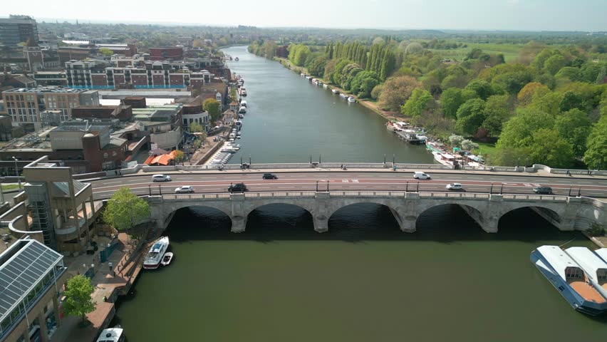 Drone aerial footage of spinning around Kingston bridge across River Thames, England. Kingston Bridge is a road bridge at Kingston upon Thames in London, England. Royalty-Free Stock Footage #1104399653