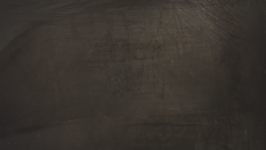 A close-up of a timelapse of a hand drawing a house with chalk on a blackboard and supporting it with hands. The concept of home, comfort and roots