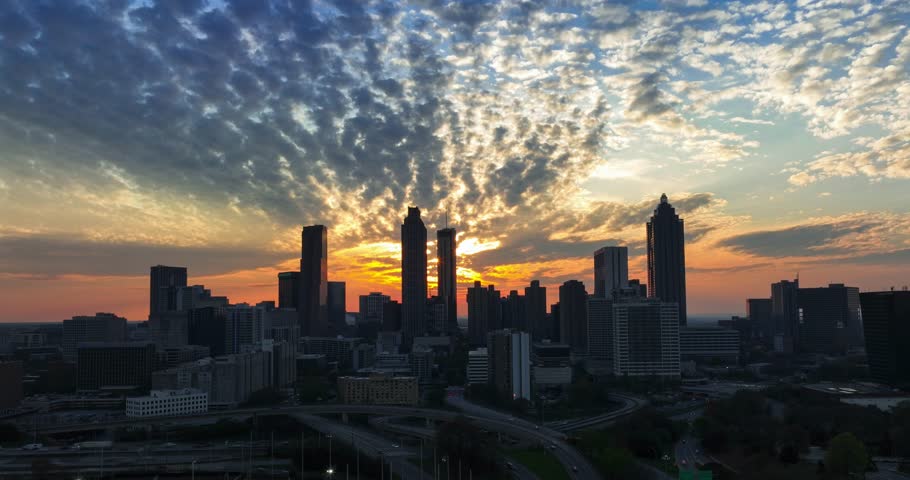 Downtown Atlanta sunset timelapse behind iconic skyscraper buildings with beautiful cloud movement and freeway traffic.