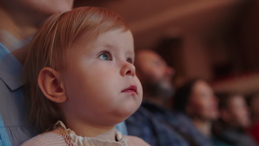 Cute little girl watching a performance in theatre or movie in cinema. Leisure entertainment for family with kids. Cultural event for children. Royalty-Free Stock Footage #1104408761