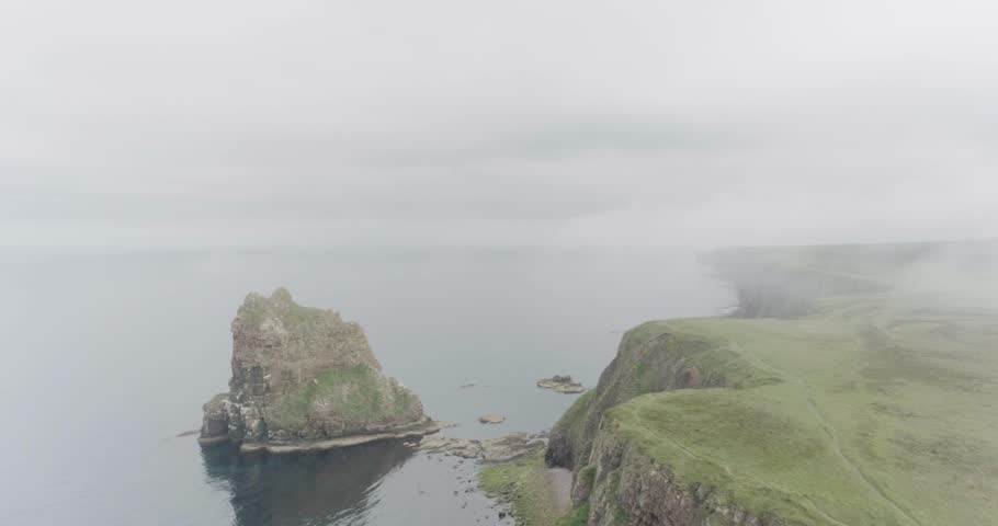 Static wide drone shot in the mist of the Stacks of Duncansby along the Scotland North Coast 500 route at John O