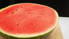 Captivating macro video of a watermelon shot with a probe lens. Witness the vibrant hues and intricate textures of this juicy fruit as it reveals its luscious red flesh, dotted with black seeds. 4K
