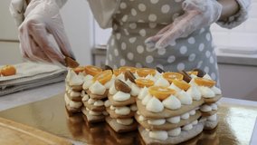 cook a cake in the kitchen. Young female pastry chef cooking a layered honey cake for the new year, pastry chef works at home, bright kitchen, video of the process