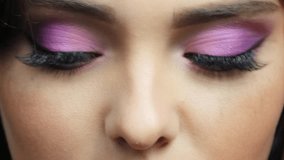 Closeup slow motion video of human female face. Footage of woman with hand near face and nails with pink manicure. Eyes are with pink shaudows beauty makeup.
 - Powered by Shutterstock - Get 15% off with code: PIKWIZARD15