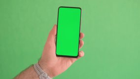 Close-up slow motion of male hand swiping green smartphone screen