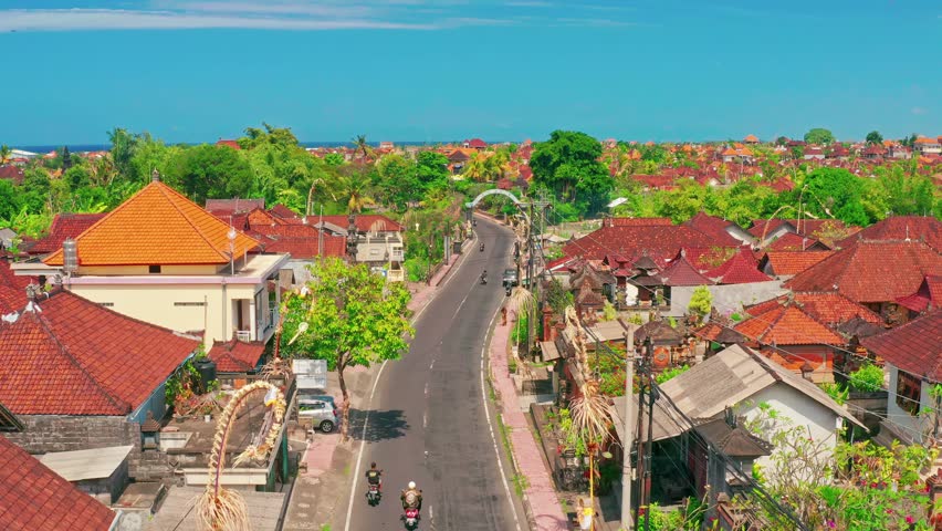 Bali, Karangasem - Indonesia - Jun 19 2022: Beautiful road in on the eastern part of Bali with scenery traditional house and blue ocean on horizon. Bali, Indonesia 4K Aerial view