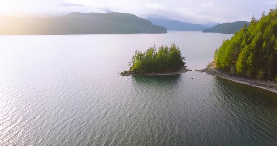 Aerial view of Harrison Lake and forest with mountain range in background