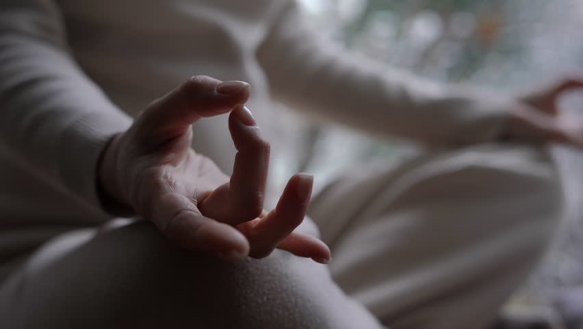 Close-up hand of unrecognizable pregnant woman meditating in lotus pose and caressing blurred belly. Happy confident relaxed Caucasian expectant practicing yoga at home indoors | Shutterstock HD Video #1104423257