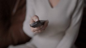 Closeup remote control in hand of pregnant unrecognizable woman switching channels on TV. Young relaxed Caucasian expectant enjoying leisure at home indoors watching movies - Powered by Shutterstock - Get 15% off with code: PIKWIZARD15