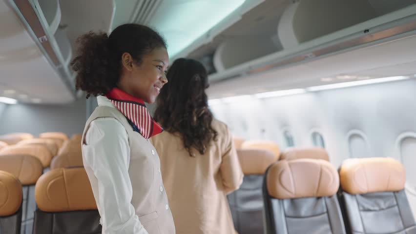 Women stewardess greeting passengers on airplane and checking passenger's boarding pass welcoming to the flight. Airline transportation Royalty-Free Stock Footage #1104428395