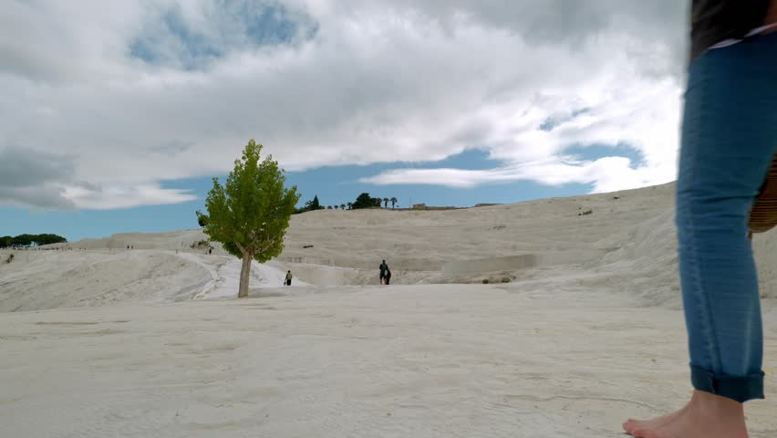 Low angle of woman walking barefoot over white travertine mineral formations