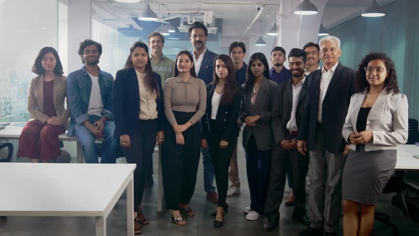 A happy confident large group or team of diverse multiethnic male and female corporate office executives or colleagues together posing and looking at the camera in modern start up business workspace  Royalty-Free Stock Footage #1104433631