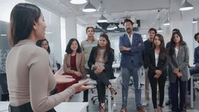 A young Indian Asian female confident entrepreneur or businesswoman passing on a project brief or communicating in a group meeting with employees or team members in a modern corporate office start up - Powered by Shutterstock - Get 15% off with code: PIKWIZARD15
