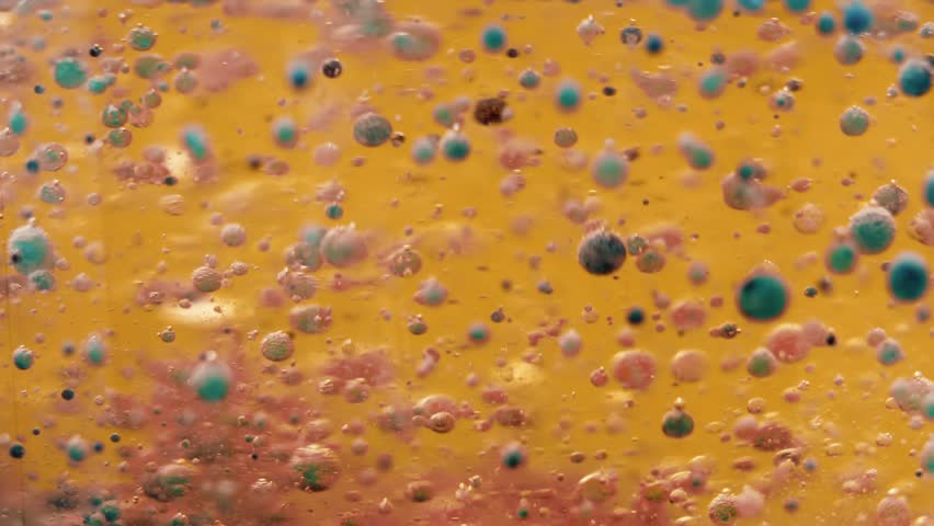 Abstraction of multicolor bubbles in a golden liquid. Bubbles slowly rotate and float to the surface. Abstract motion design on a glowing background | Shutterstock HD Video #1104434743