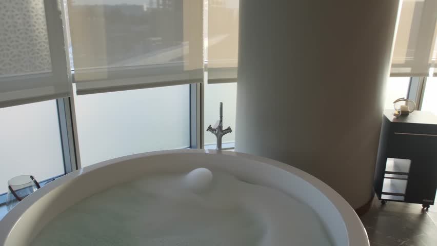 Massage room in an expensive premium hotel with two daybeds and a bathtub full of water and foam