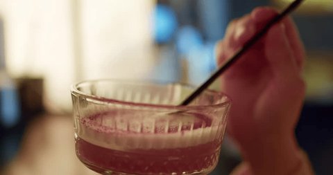 Стоковое видео: Captivating Cocktail Delight: High-Quality Close-Up of a Girl Enjoying a Pink Beverage in a Stylish Bar Setting