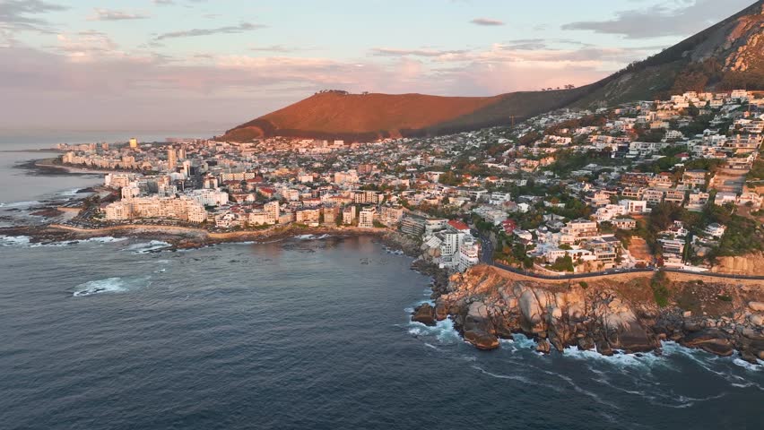 Aerial view of Atlantic Seaboard sunset with Lion’s Head Mountain, Bantry Bay and Sea Point from Atlantic Ocean, Cape Town, South Africa. Royalty-Free Stock Footage #1104442363