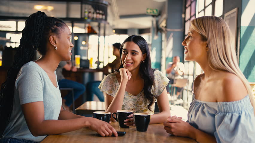 Group of multi-cultural female friends meeting in restaurant or coffee shop posing for selfie on mobile phone and posting to social media - shot in slow motion Royalty-Free Stock Footage #1104443879