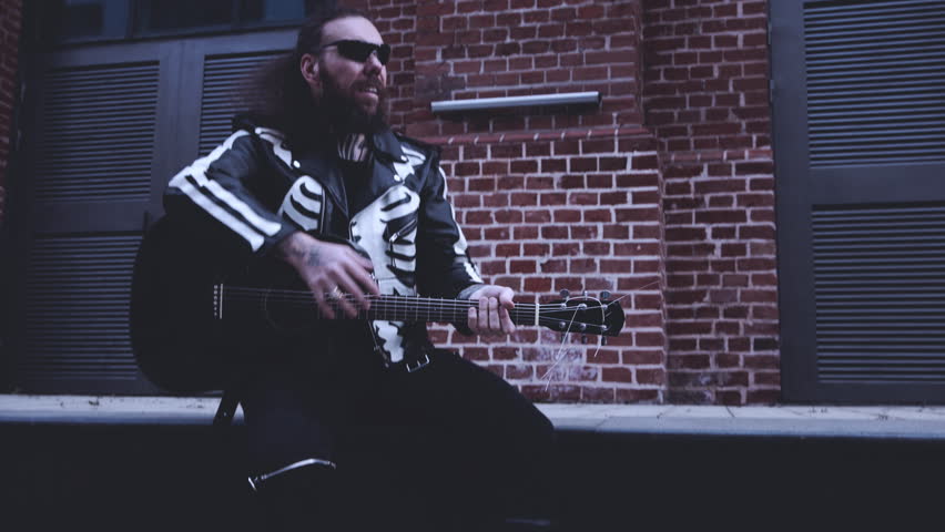 Brutal Man In Black Clothes With A Guitar