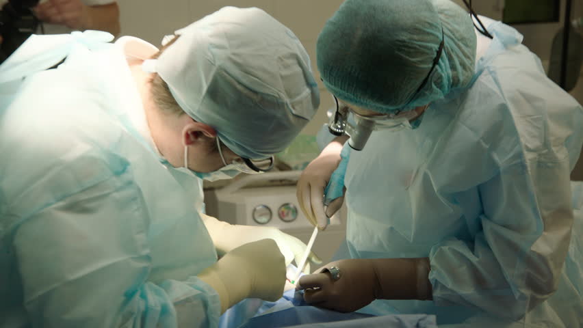 Dental surgery, dental clinic, dentist doctor and assistant in blue suits during implant operation Royalty-Free Stock Footage #1104446735