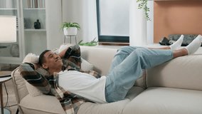 Happy African American guy ethnic man homeowner renter fall on soft sofa enjoy relax rest cozy comfortable couch feel overjoyed after working moving day relaxing lying at own home rented flat napping - Powered by Shutterstock - Get 15% off with code: PIKWIZARD15