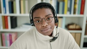 African american woman student smiling confident wearing headphones at library university