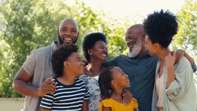 Portrait of loving multi-generation family standing outside in garden, park or countryside looking at camera- shot in slow motion - Powered by Shutterstock - Get 15% off with code: PIKWIZARD15
