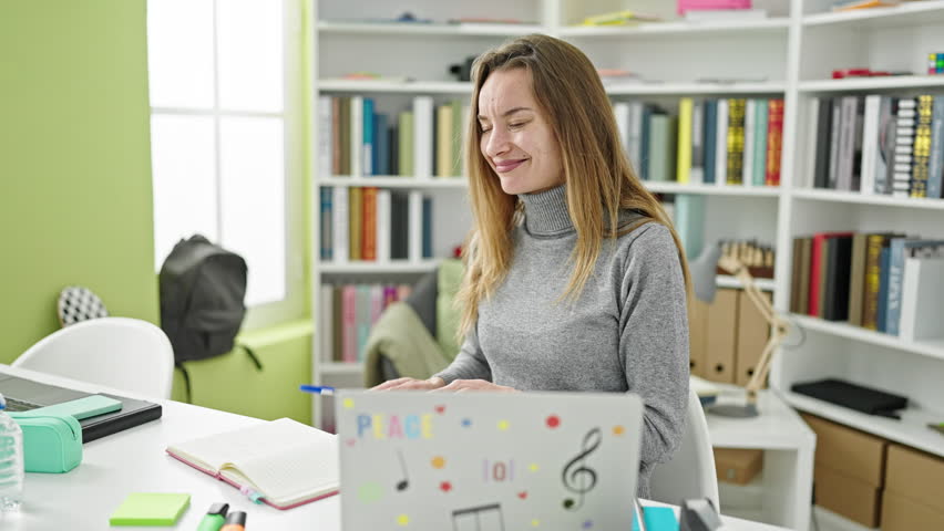 Young caucasian woman student using pen as a drummer at library university