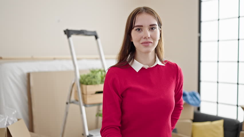 Young hispanic woman smiling confident holding house keys at new home