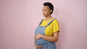 Young pregnant woman smiling confident touching belly over isolated pink background - Powered by Shutterstock - Get 15% off with code: PIKWIZARD15
