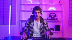 Caucasian young Esport male gamer play online video game on computer. Handsome man gaming player feel happy and excited, enjoy technology broadcast live streaming while plays cyber tournament at home.