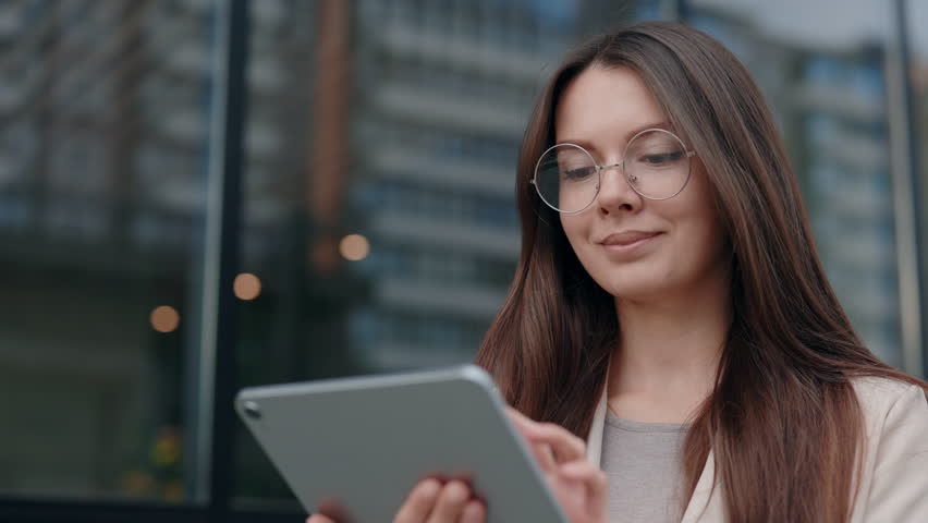 Young Attractive Woman Looking at Tablet Screen Outdoors. Elegant Businesswoman Chatting Online with Digital Device Outside. Portrait of Business Lady Using Tablet Computer Near Office Building Royalty-Free Stock Footage #1104458731