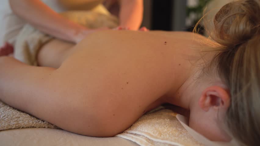Body massage treatment. Woman having massage in the spa salon. Masseur working on his back and shoulders.	 Royalty-Free Stock Footage #1104461251