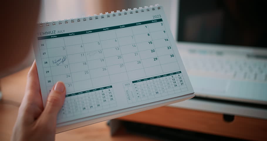 Woman planning vacation in calendar on table desk