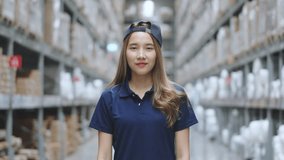 Portrait of Asian female smiling while standing in warehouse factory. 