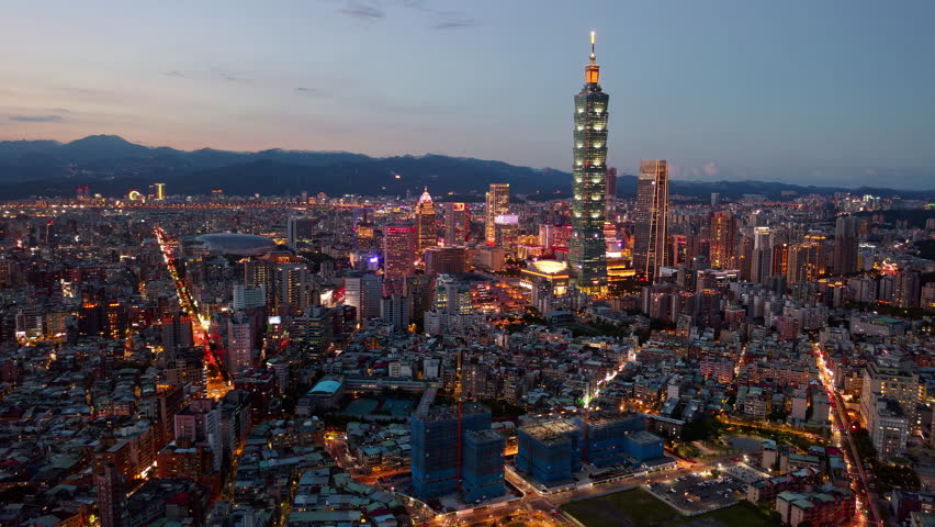 Aerial hyperlapse of Downtown Taipei at night, the vibrant capital of Taiwan, with 101 Tower standing out amid skyscrapers in XinYi Commercial District and city lights dazzling under blue twilight sky Royalty-Free Stock Footage #1104469971