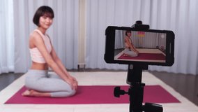 A woman recording fitness videos on her smartphone.