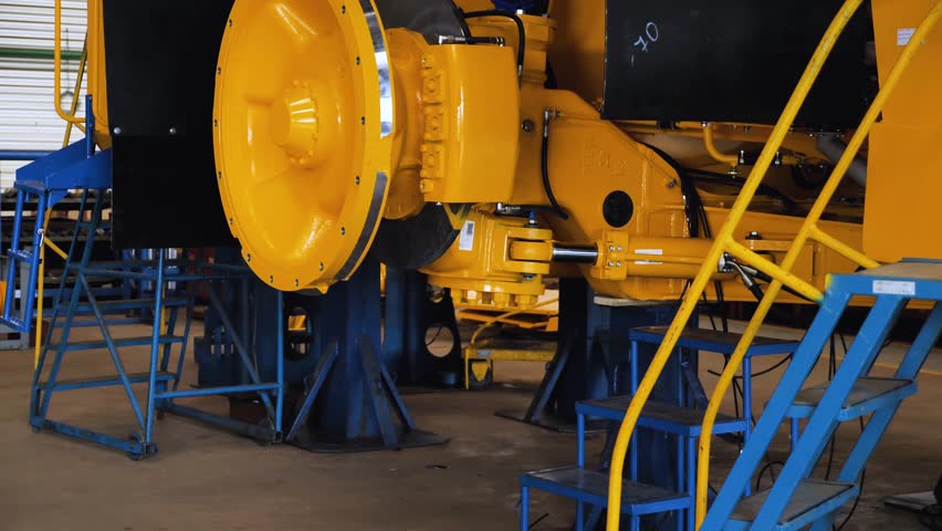Dump truck cabin on the assembly line in the workshop for the production of large yellow quarry trucks. The workshop of plant. Close-up