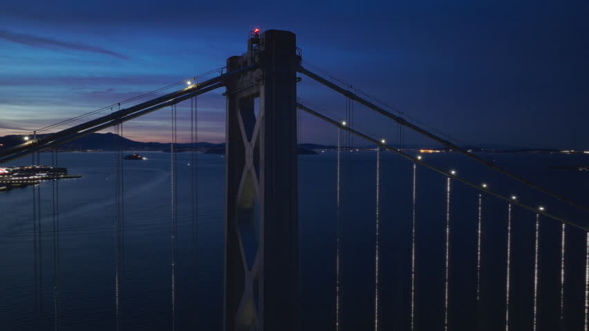 Flight over night illuminated San Francisco city downtown. Aerial night traffic on Bay Bridge with downtown evening panorama 4K. Downtown San Francisco buildings skyline at night with scenic dusk sky