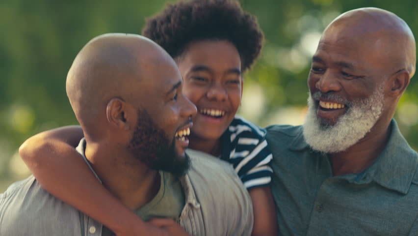 Portrait of loving multi-generation male family outdoors in garden at home or in countryside - shot in slow motion