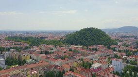 Inscription on video. Graz, Austria. The historic city center aerial view. Mount Schlossberg (Castle Hill). Text from small balls, Aerial View