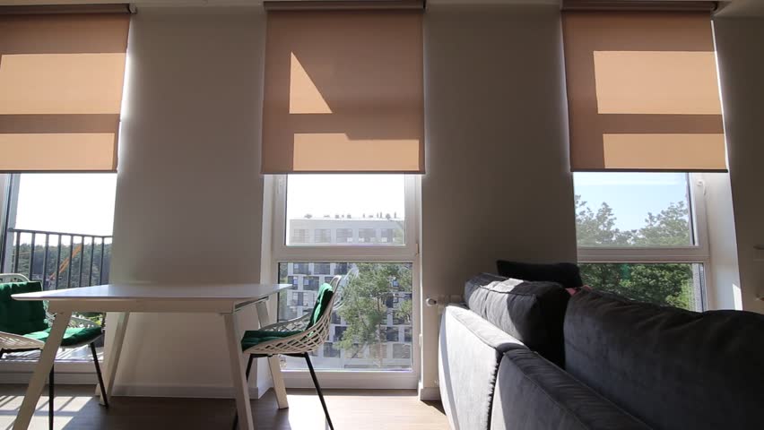 Motorized roller shades. Automatic roller blinds beige color on large windows. Video Remote Control Shades in the apartment., a Technology Video by Astibuk