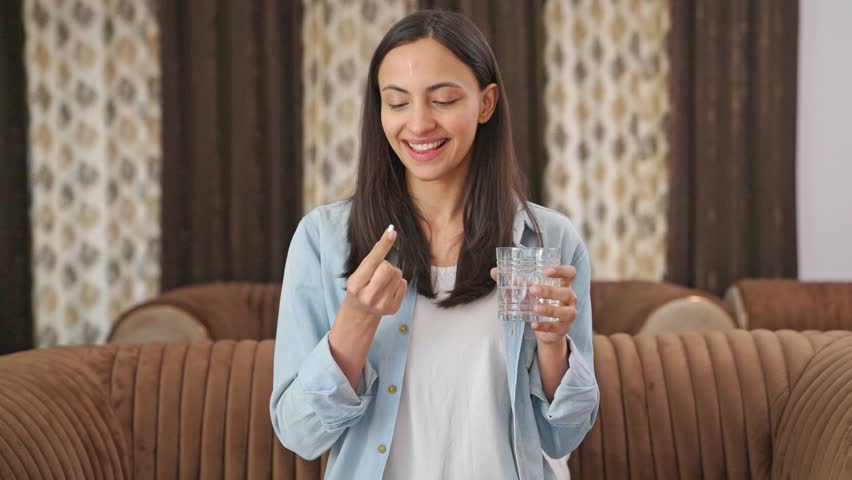 Happy Indian woman taking a medicine