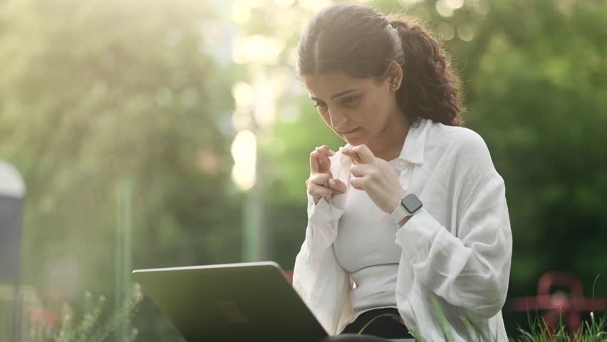 Young indian woman with crossed fingers wait for news celebrate online win success great news message feel happy on laptop and looking at camera with thumbs up at park Triumph Lucky Wow concept Royalty-Free Stock Footage #1104496671