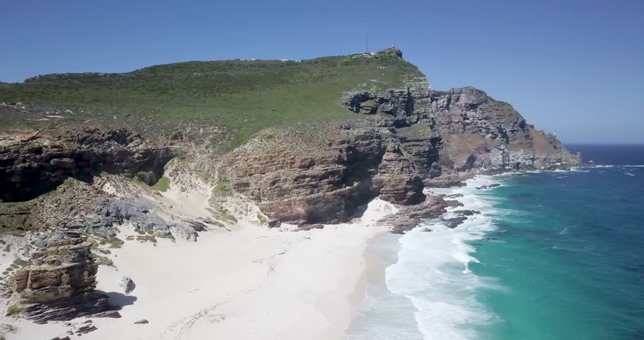 4K Aerial drone footage of Diaz Beach, Cape Town, South Africa. Rocky cliffs and Turquoise clean water with white sand beach in Cape Peninsula. Cape Point Nature Reserve with specific fauna and flora
