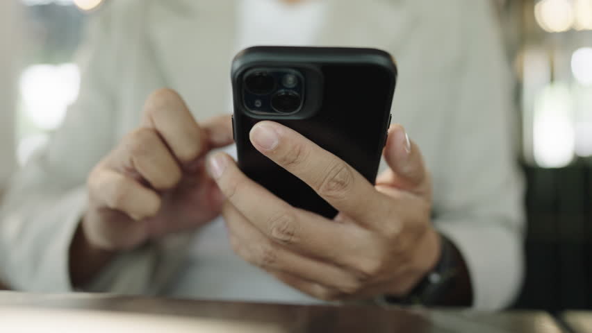 Close up the hand using smartphone touching display and scrolling working new job on internet at coffeeshop | Shutterstock HD Video #1104505699