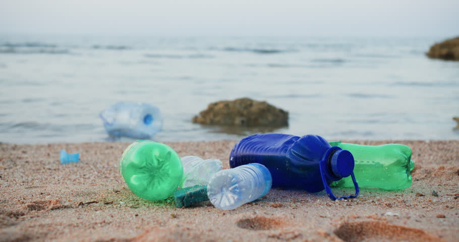 Plastic bottles and garbage on sea sandy beach, environmental pollution.  | Shutterstock HD Video #1104510333