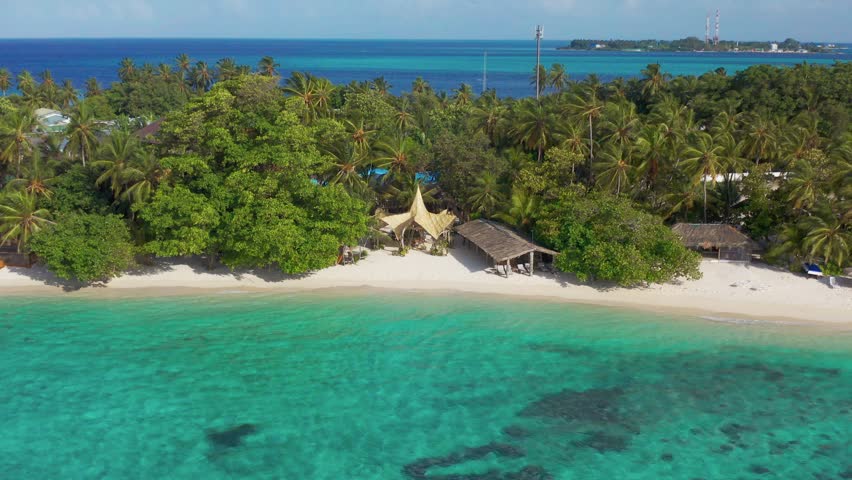 Aerial view on eco resort on a white sand beach with thatched huts and lush tropical vegetation on Bora Bora, French Polynesia. Royalty-Free Stock Footage #1104513303